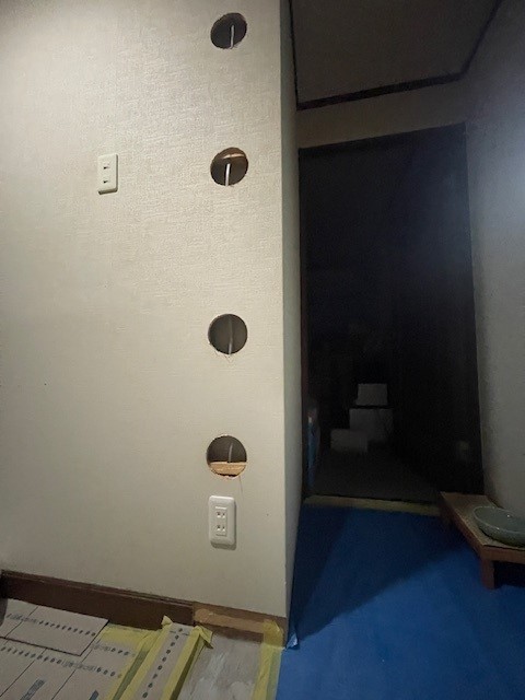 玄関にコンセントを付けてもらうために壁に穴が開いてます。後で上から新しい壁紙が貼られます。